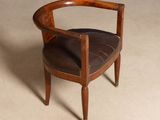 a wooden chair with a leather seat on a beige floor