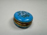 a small blue box with flowers on it sitting on a table