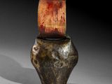 an old vase with a wooden lid sitting on top of a table