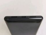 a close up of the back of a black phone on a white surface