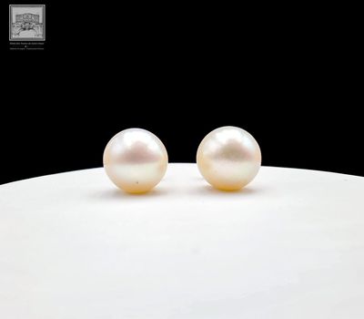 deux perles blanches reposent sur une surface blanche