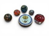 a lot of different colored marbles on a white surface