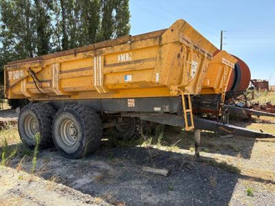un camion-benne jaune garé sur le bord de la route