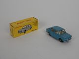 a small toy car next to a box on a white surface