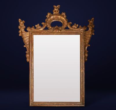 un miroir ancien dans un cadre doré, sur fond bleu foncé