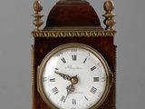 une petite horloge en bois avec des chiffres romains