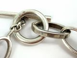 a close up of a silver chain with two rings on it