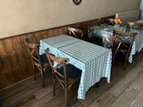 tables and chairs with blue and white checkered tablecloths in a restaurant