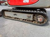 a close up of a red and black excavator on the ground