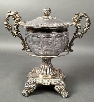 an antique silver plated bowl with a lid on a stand