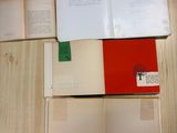 several open books sitting on top of a wooden table next to a cup of coffee