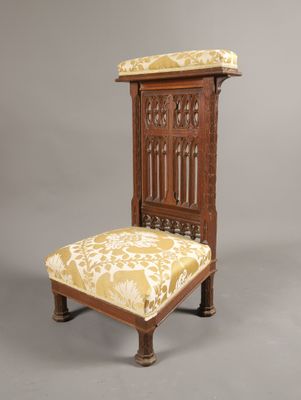 une vieille chaise en bois dont l'assise est recouverte d'un tissu jaune et blanc