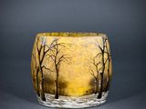 a glass vase with a painting of trees on it