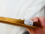 une personne tenant un morceau de bois sur lequel est collé un autocollant