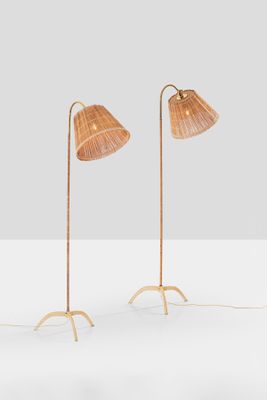 a pair of floor lamps with rattan lampshads on each of them