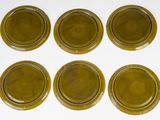 six brown glass coasters sitting on top of a white surface