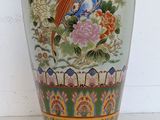a vase with a bird on it sitting on a table
