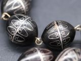 some very pretty black and white beads on a black surface