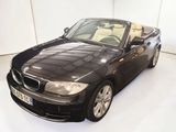 une photo d'une BMW décapotable noire garée dans une pièce blanche