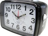 a black alarm clock sitting on a white surface