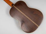 a close up of an acoustic guitar on a white surface