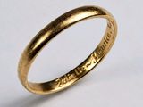gros plan d'une bague en or sur une surface blanche