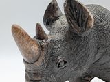 a statue of a rhino standing on a white surface