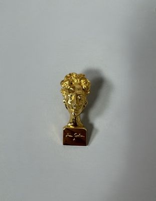 a gold statue of a man with a plaque on it