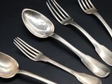 six silver spoons and a fork on a black surface