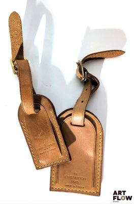 étiquettes à bagages en cuir sur fond blanc, avec un cordon marron
