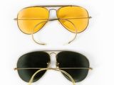 deux paires de lunettes de soleil jaunes et noires sur fond blanc