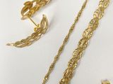 two pieces of gold jewelry including a necklace, earrings, and ring