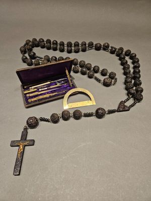 rosary with a cross and a wooden box on a table