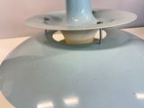a light blue lamp that is on a white table