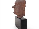 an image of a sculpture of a man ' s head on a black stand