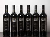six bouteilles de vin sont alignées sur une table en bois