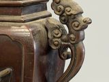 a large bronze vase with a bird on it