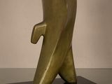 sculpture en bronze représentant un oiseau, posée sur un socle noir, elle-même posée sur une table