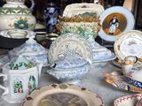 many plates and cups on the table with a lamp in the background