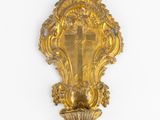 an ornate gold wall sconce with a cross on it