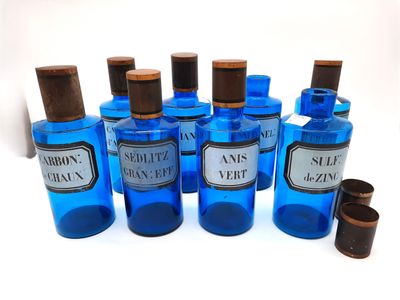 six bottles of blue glass with brown caps and a wooden stopper