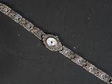 une image représentant une montre-bracelet posée sur une surface noire