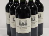 four bottles of red wine are lined up on a white surface