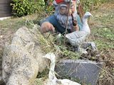 a statue of a gnome sitting on a pile of dead animals