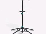 a black tripod stands on a white background with a green handle