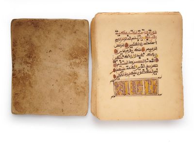 un livre ouvert, portant des inscriptions en arabe, posé sur une surface blanche