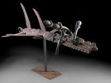 une photo d'une sculpture représentant un oiseau et un bateau, posée sur un socle