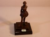 statue en bronze représentant une femme tenant une raquette de tennis, posée sur un socle noir