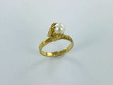 a close up of a gold ring with a pearl on it