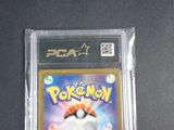 the pokemon card is in a plastic case on a table